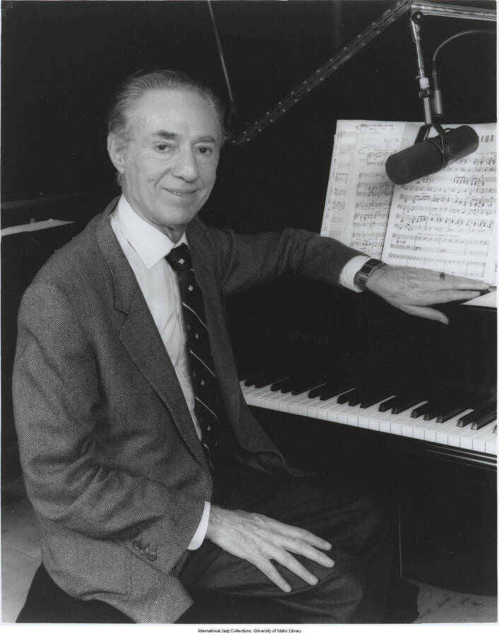 10 x 8 inch photograph. Leonard Feather at the piano with microphone