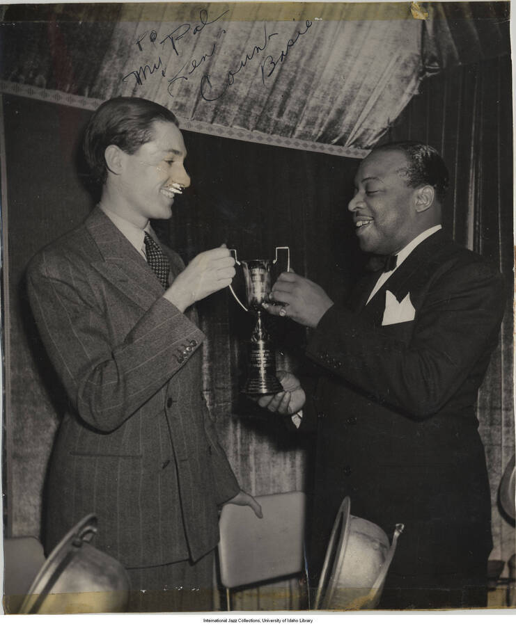 8 3/4 x 7 1/2 inch signed photograph; Leonard Feather and Count Basie holding a trophy. The photograph is dedicated to Leonard Feather