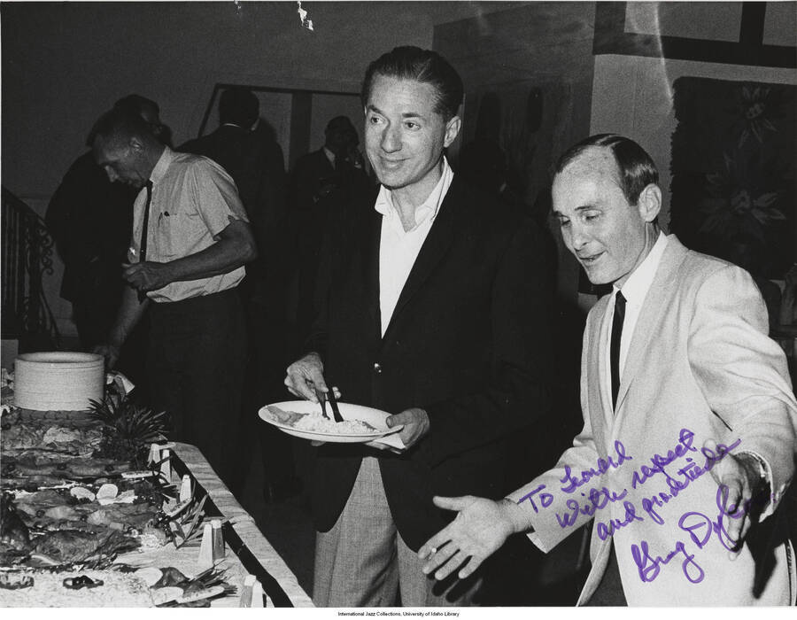 8 1/2 x 11 inch signed photograph; Leonard Feather with Greg Dykes, leader of the Sounds of Synanon quintet, in a banquet. The photograph is dedicated to Leonard Feather