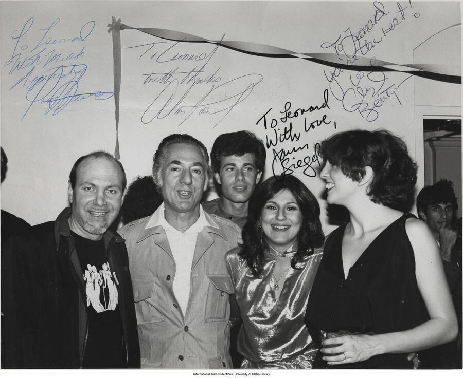 10 x 8 inch signed photograph; Leonard Feather with unidentified men and women. The photograph is dedicated to Leonard Feather by the four persons, including a woman named Siegel