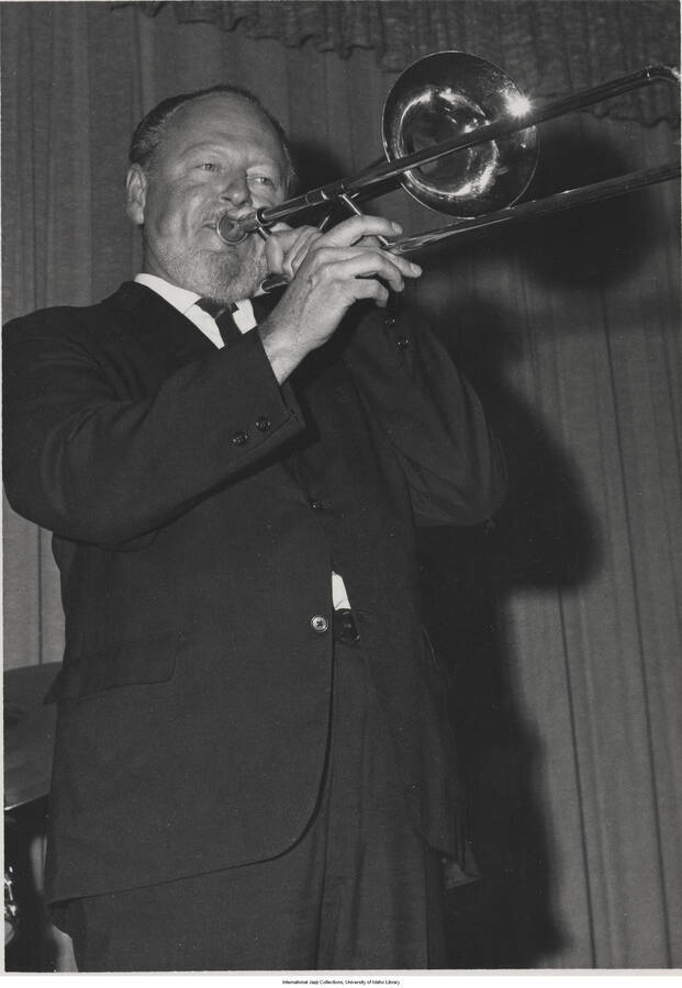 7 x 5 inch photograph; Lou  McGarity playing the trombone. Handwritten on the back of the photograph: Lou  McGarity; Disneyland, 1967-09-30