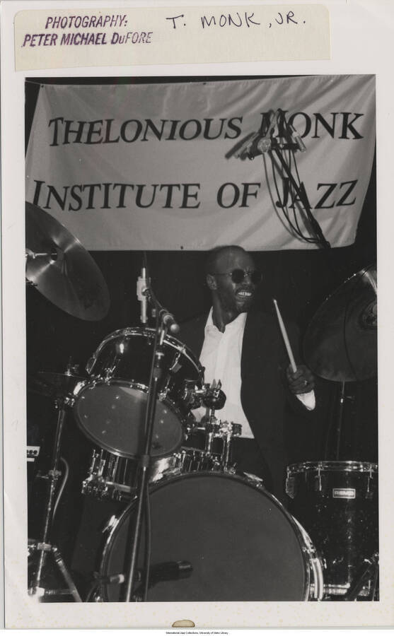 8 x 5 inch photograph; a baterist. T. S. Monk playing the drums. A banner in the background of the stage reads: Thelonious Monk Institute of Jazz