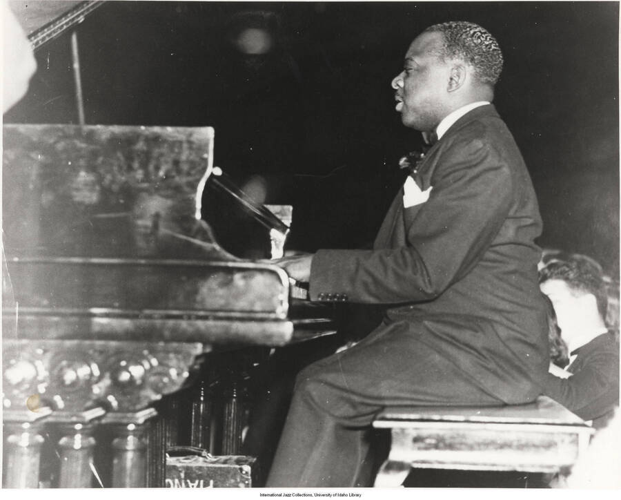 8 x 10 inch photograph; Count Basie playing the piano