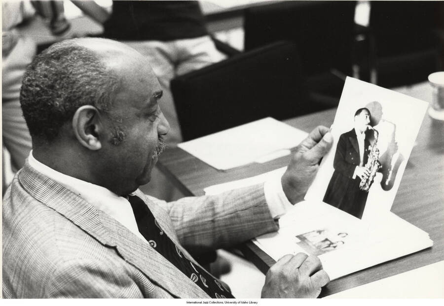 8 x 10 inch photograph; Count Basie holding a picture of an unidentified saxophonist