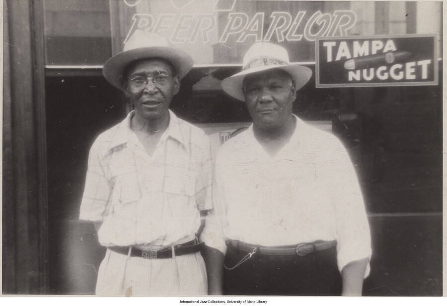 3 1/4 x 4 1/2 inch photograph; Sidney Bechet and Pops Foster in front of a store with sign that reads: Beer Parlor; Tampa Nugget