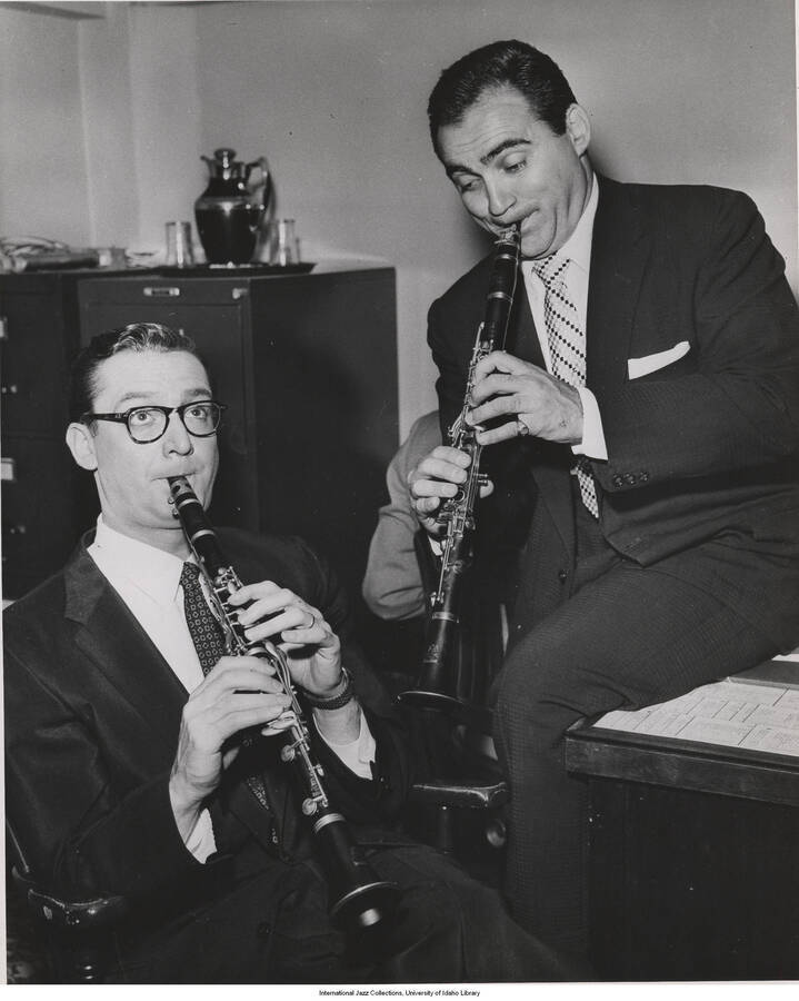 10 x 8 inch photograph; Steve Allen practicing clarinet with Sol Yaged in an office