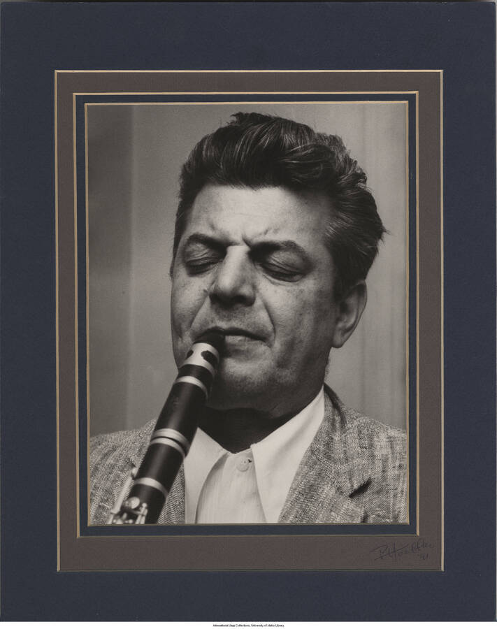 10 x 8 inch signed photograph; Joe Marsala playing the clarinet.  The photograph is in triple mat with no frame. Handwritten on the back of the photograph: Joe Marsala, 1958 (July), East Greenwich, Rhode Island (Spencer Avenue). It was dedicated from Paul to Gene, in 1991 and from Gene to Jane and Leonard Feather, in 1993