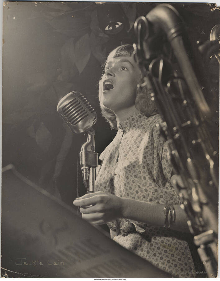 14 x 11 inch photograph; Jackie Cain, Royal Roost, NYC, circa 1948. A saxophone is partially visible as is the cover of a score that reads: The Great Charlie Ventura