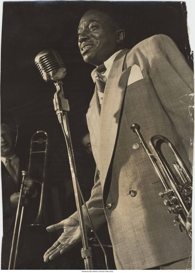 13 1/2 x 9 3/4 inch photograph; Hot Lips Page at the microphone holding the trumpet on his left side