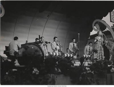 7 x 9 1/2 inch photograph; Swedish singer Alice Babs accompanied by trumpet player Rolf Ericson, alto saxophonist Arne Domnérus, tenor saxophonist Rolf Blomquist, and baritone saxophonist Lars Gullin