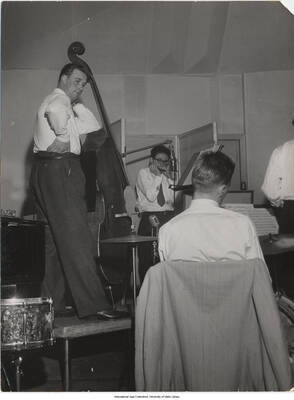 9 1/2 x 7 inch photograph; bassist Gunnar Johnson, harmonica player Toots Thielemans, and an unidentified drummer, performing in a studio