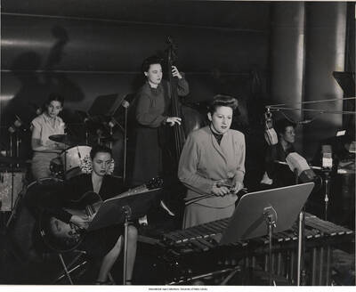10 x 8 inch photograph; Mary Lou Williams All-Stars at RCA. Left to right: Rose Gottesman, Mary Osborne, June Rotenberg, Margie Hyams, MLW. This photograph is published in Leonard Feather's book The Jazz Years: Earwitness to an era