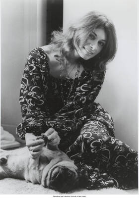 10 x 8 inch photograph; Joanne Grauer playing with a dog on the floor (1 duplicate)