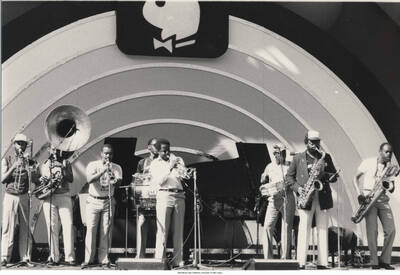 5 x 7 inch photograph; unidentified musicians performing. Observable above the stage is the logo of Playboy Magazine