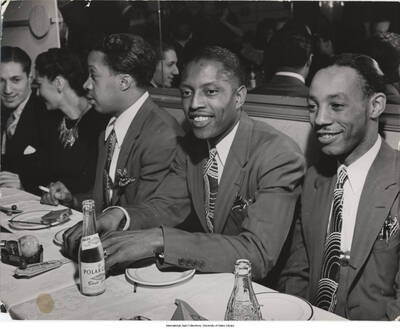 7 3/8 x 9 1/4 inch photograph; Leonard Feather with unidentified men and woman, in a restaurant. Place cards on the tables read: Famous Door. Stamped on the back of the photograph: Reproduction not permitted; LIFE Magazine; David O. Alber, NY