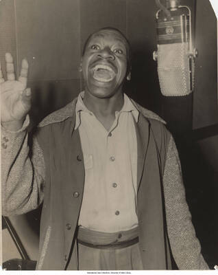 10 x 8 inch photograph; unidentified singer in a recording studio