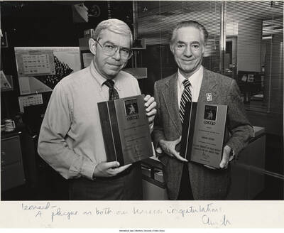 8 x 10 inch signed photograph; Leonard Feather and an unidentified man holding award plaques from the American Society of Composers, Authors and Publishers-ASCAP. Leonard Feather received this award for his essay Memories of Billie Holiday, published in The Los Angeles Times. The photograph is dedicated to Leonard Feather from [Clinch?]