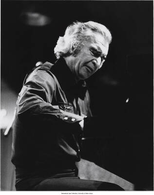 10 x 8 inch photograph; Dave Brubeck playing the piano. Handwritten on the back of the photograph: Dan Baliotti