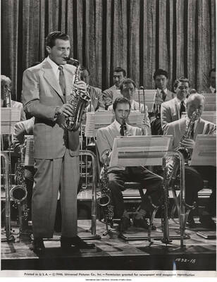 10 x 8 inch photograph; Charlie Barnet. Label on the back of the photograph reads: Charlie Barnet, Decca Recording artist, brings his popular orchestra to the screen in a new Universal musical film featurette