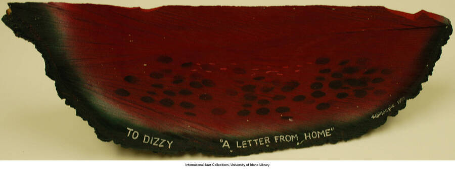 A carved piece of wood painted to look like a watermelon with the inscription: 'To Dizzy &quot;A letter from home&quot; Gillespie 1992'