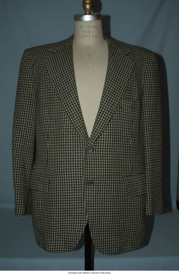 Black and white houndstooth 100% wool.  Fully lined with gray acetate.  Label reads Saks Fifth Avenue,  2 button, single vent.