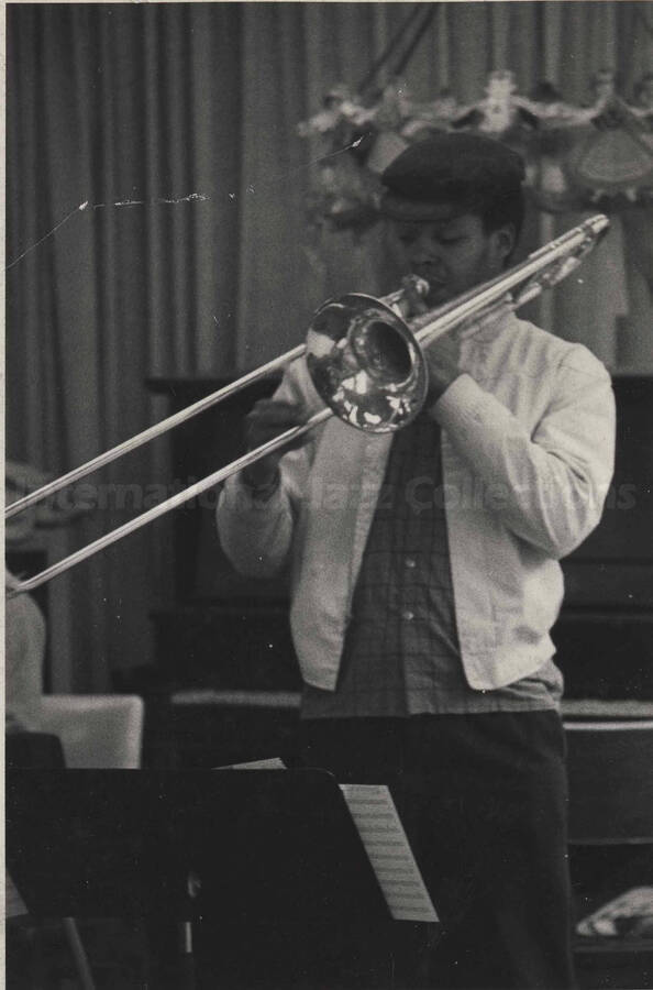 Unidentified trombonist performing, [in a library?]