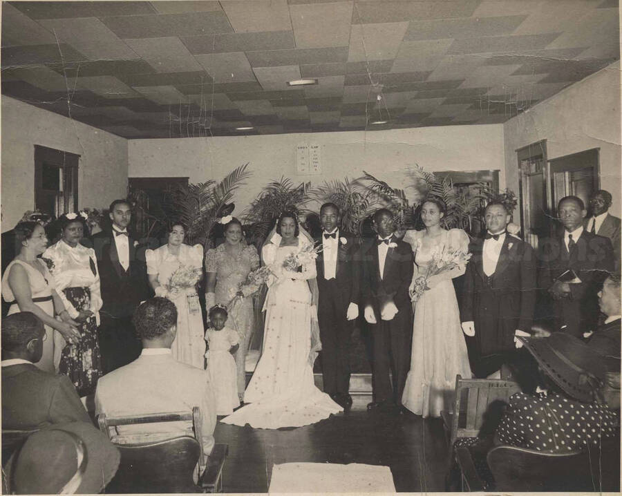 A wedding picture. Depicted are unidentified bride, groom, and the bridal party