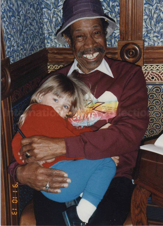 Al Grey holding a girl on his lap. Handwritten on the back of the photograph: B. S. Weil.