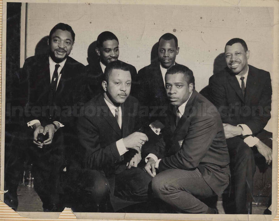 Al Grey posing with five unidentified men. This photograph is pasted on a photo album
