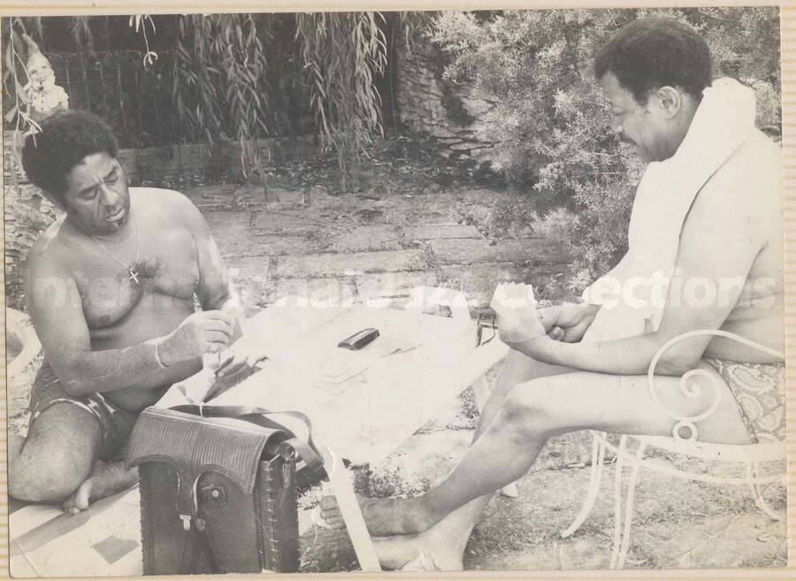 Al Grey playing cards with [Dizzy Gillespie]. This photograph is pasted on a photo album