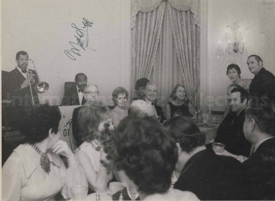 Al Grey and band performing for the guests at Governor Milton Shapp's inaugural party at the Governor's Mansion in Harrisburg, PA. The photograph is signed by Governor Milton Shapp. This photograph is pasted on a photo album