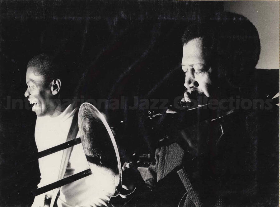 Al Grey performing beside an unidentified musician. This photograph is pasted on a photo album