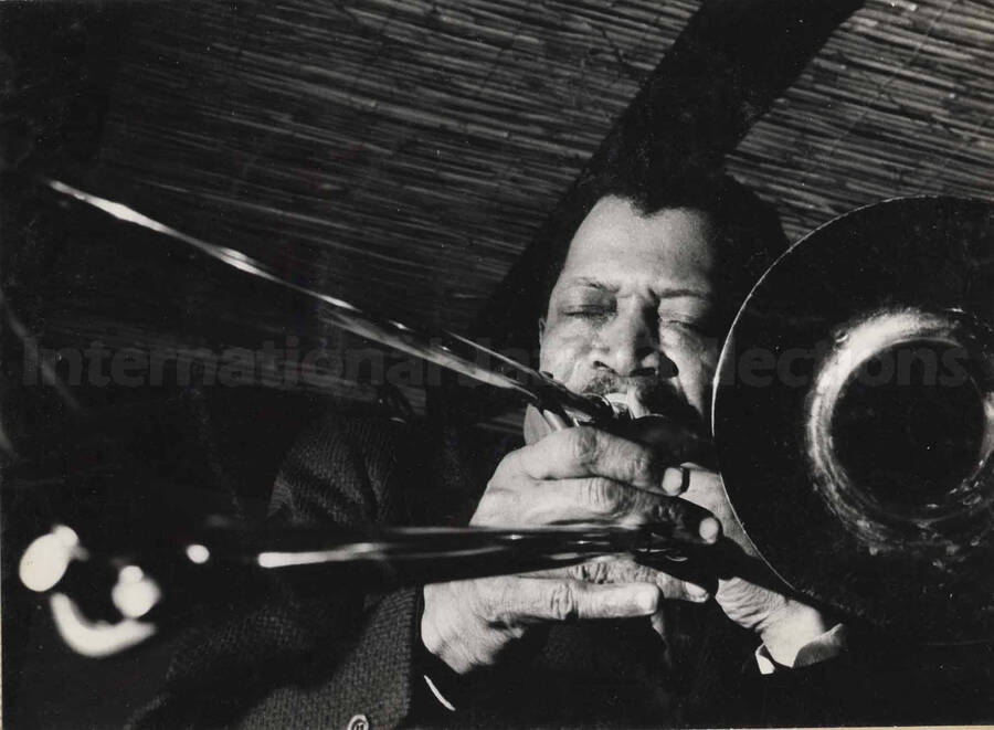 Al Grey playing the trombone. This photograph is pasted on a photo album