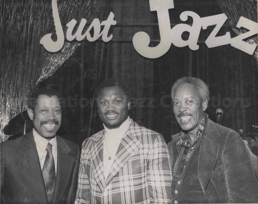 Al Grey posing with Joe Fraizer, famous boxer from Philadelphia. On the background wall the words: Just Jazz. This photograph is pasted on a photo album