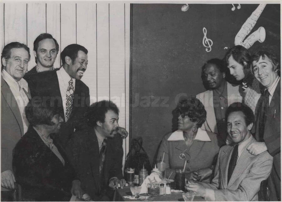 Al Grey, Ella Fitzgerald, and unidentified persons. This photograph is pasted on a photo album