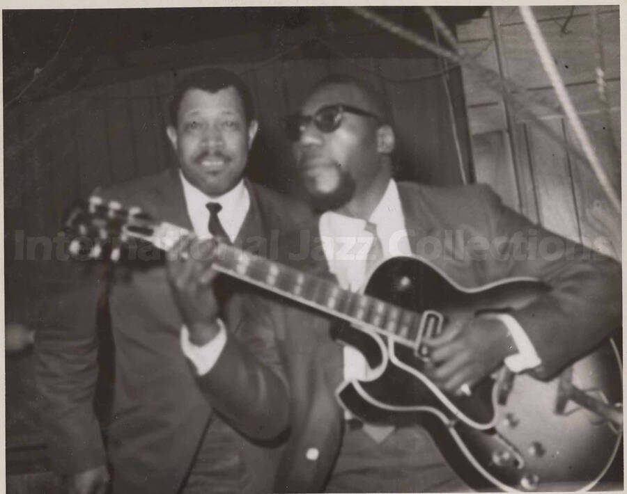 Al Grey posing with unidentified guitarist. This photograph is pasted on a photo album