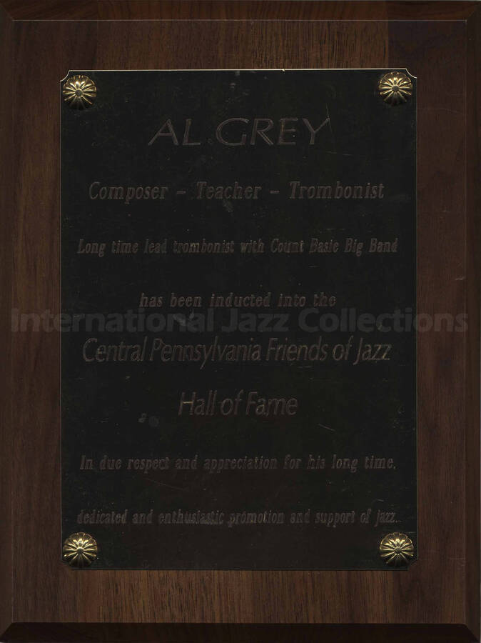 Wood finish plaque with gold engraved plate. Al Grey is inducted into the Central Pennsylvania Friends of Jazz Hall of Fame in homage to his long career as lead trombonist with Count Basie Big Band. A label on the back of the plaque reads: Award Connection, New Cumberland (PA)