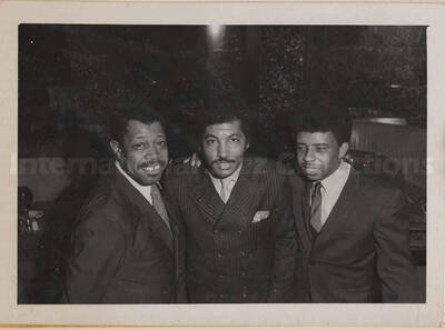 Al Grey posing with two unidentified men. This photograph is pasted on a photo album sheet.