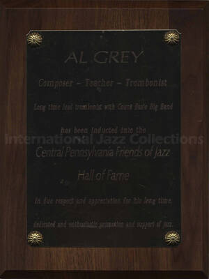 Wood finish plaque with gold engraved plate. Al Grey is inducted into the Central Pennsylvania Friends of Jazz Hall of Fame in homage to his long career as lead trombonist with Count Basie Big Band. A label on the back of the plaque reads: Award Connection, New Cumberland (PA)