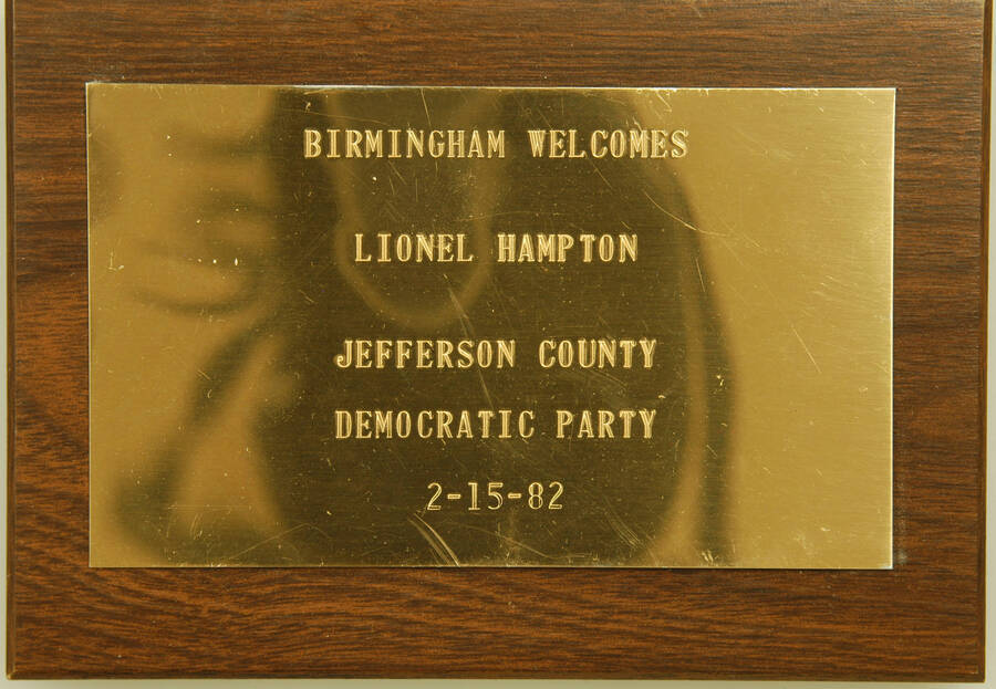 Plaque. 4 1/4"x6 1/8" Wood finish plaque with engraved plate Birmingham welcomes Lionel Hampton. Jefferson County Democratic Party.  Birmingham, AL, Feb. 15, 1982