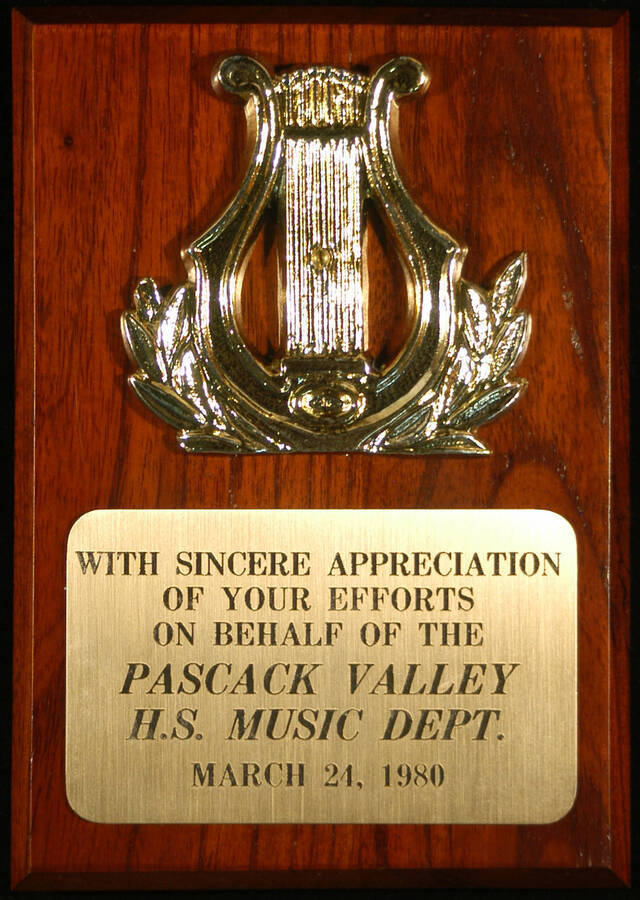 Plaque. 7"x5" Wood finish plaque with musical theme and engraved plate With sincere appreciation of his efforts on behalf of the Pascack Valley H. S. Music Dept. [New Jersey], Mar. 24, 1980