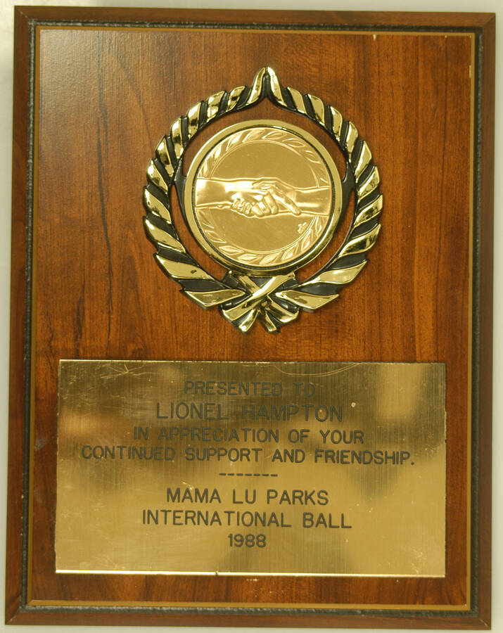 Plaque. 9"x7" Wood finish plaque with disc and engraved  plate To Lionel Hampton in appreciation of his continued support and friendship on the occasion of the Mama Lu Parks International Ball. 1988