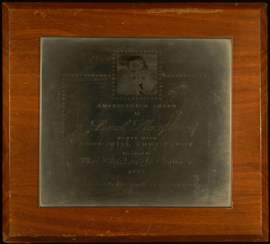 Plaque. 10"x11" Wood finish plaque with engraved plate, including an engraved bust of Lionel Hampton Americanism Award presented to Lionel Hampton, world-wide good will ambassador, by The Pittsburgh Courier. 1955