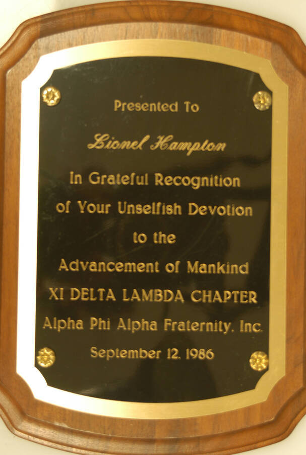 Plaque.10 1/2"x 8" Scallop wood finish plaque with engraved double plate To Lionel Hampton from the XI Delta Lambda Chapter - Alpha Phi Alpha Fraternity in recognition of his devotion to the advancement of mankind. Sep. 12, 1986