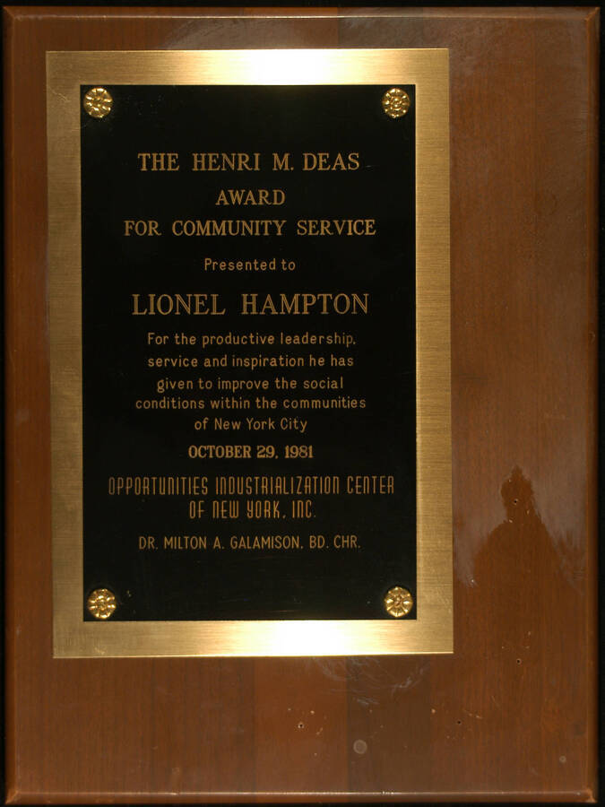 Plaque. 12"x 9" Wood finish plaque with engraved double plate The Henri M. Deas Award for Community Service presented to Lionel Hampton by the Opportunities Industrialization Center of New York for the productive leadership, service, and inspiration he has given to improve the social conditions within the communities of New York City. Milton A. Galamison, Bd. Chr. New York, NY, Oct. 29, 1981.