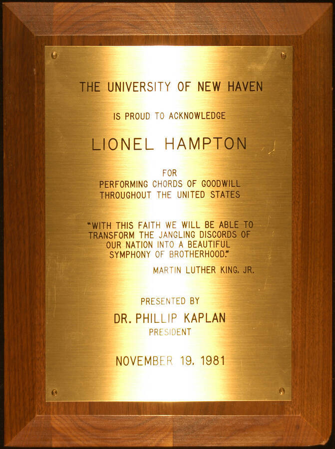 Plaque. 12"x9" Wood finish plaque with engraved plate To Lionel Hampton from the University of New Haven for performing chords of goodwill throughout the United States. Phillip Kaplan, President. Nov. 19, 1981. (With a quote from Martin Luther King, Jr.)