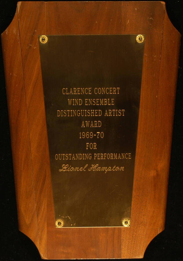 Plaque. 12"x8 3/4" Wood finish plaque with engraved plate 1969-70 Clarence Concert Wind Ensemble Distinguished Artist Award presented to Lionel Hampton for outstanding performance. [New York], 1970