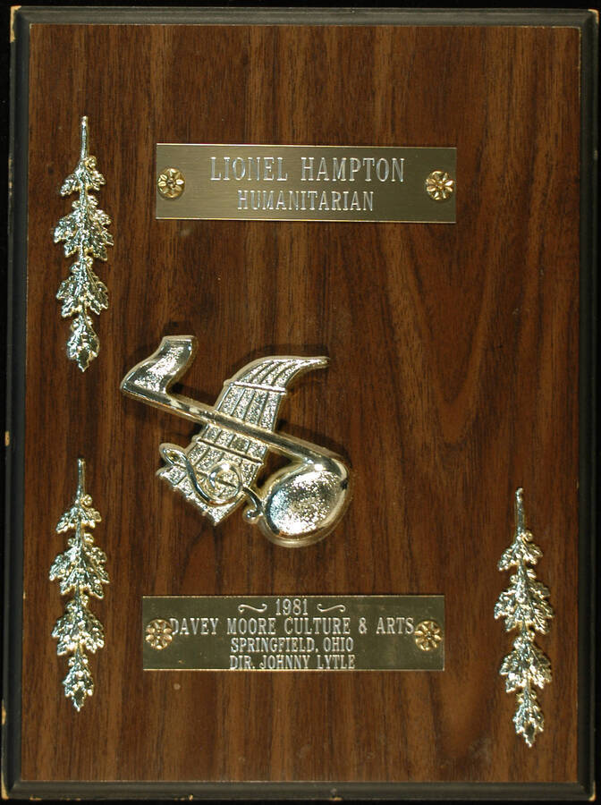 Plaque. 12"x9" Wood finish plaque with musical theme, four laurel leaves and two engraved plates To Lionel Hampton from Davey Moore Culture and Arts. Johnny Lytle, Director. Springfield, OH, 1981
