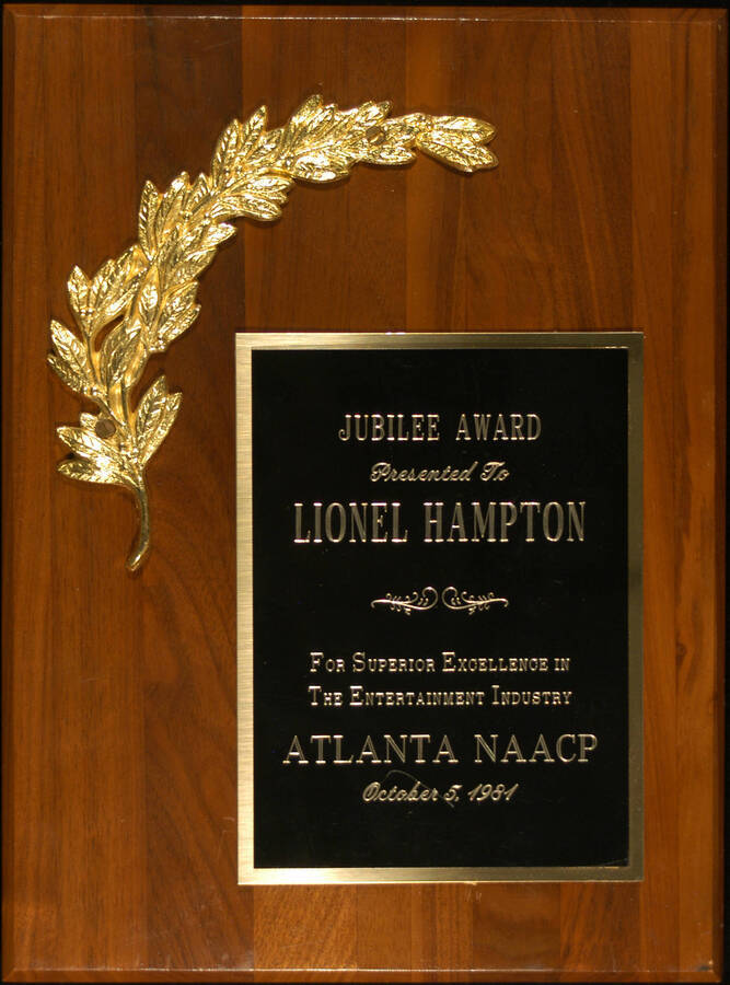 Plaque. 12"x9" Wood finish plaque with engraved double plate and a laurel leaf Jubilee Award presented to Lionel Hampton by the Atlanta branch of National Association for the Advancement of Colored People-NAACP for superior excellence in the entertainment industry. Atlanta, GA, Oct. 5, 1981