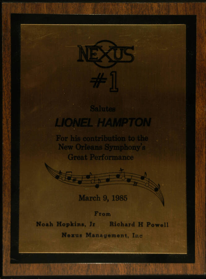 Plaque. 12"x9" Wood finish plaque with screen printed double plate Nexus # 1 salutes Lionel Hampton for his contribution to the New Orleans Symphony's great performance. Noah Hopkins, Jr. and Richard H. Powell, Nexus Management.  New Orleans, LA, Mar. 9, 1985